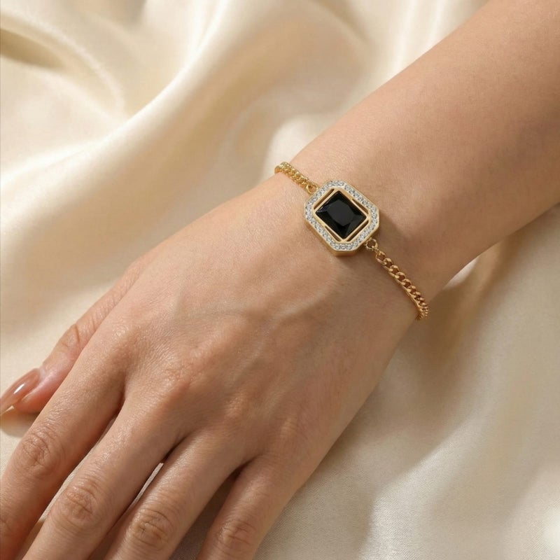 انسيال ذهبي مصنوع من الستانلس ستيل المقاوم للصدأ، بحجر أسود ملكي محاط بإطار مرصع بالزركون اللامع. تصميم رقيق فاخر، مع قفل قابل للتعديل ليناسبكِ. - Image 3